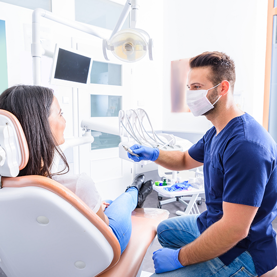 Dentist talking to a patient in the treatment chair