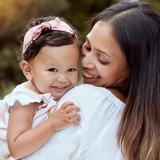 Mother holding her baby outdoors