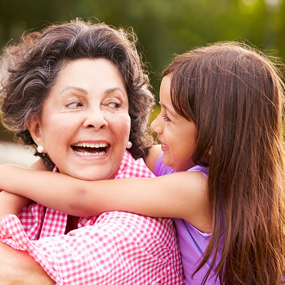 Woman and young girl hugging outdoors