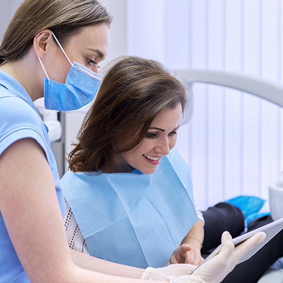 Cosmetic dentist showing a tablet screen to a patient