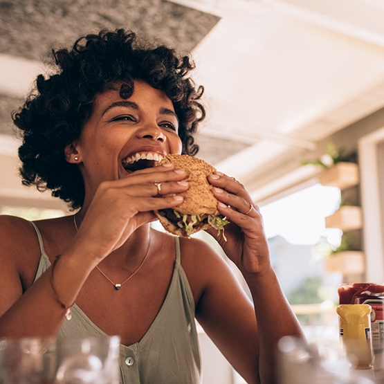 Woman taking a bite of a burger