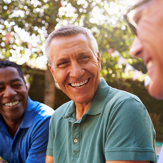 Three men laughing together outdoors