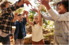 Circle of smiling kids putting their hands together