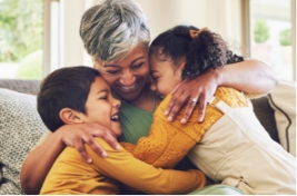 Two children hugging their grandmother