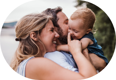 Smiling man and woman holding their baby