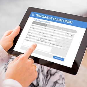 Person filling out insurance claim form on tablet