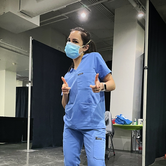 Doctor Director in scrubs making finger guns