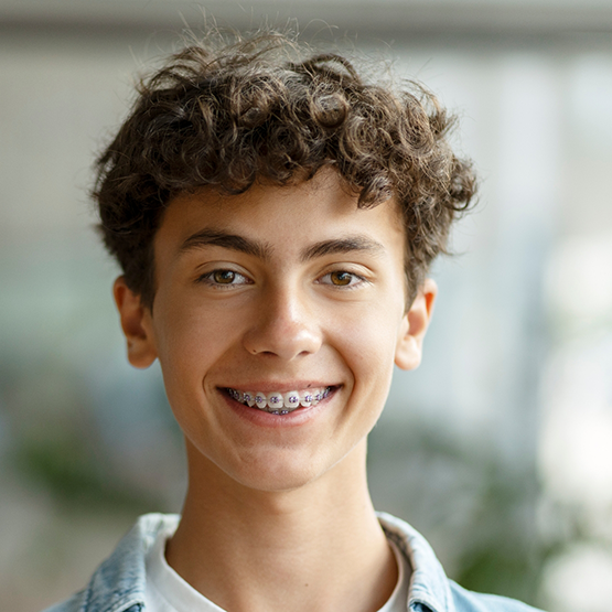 Teenage boy with traditional braces smiling