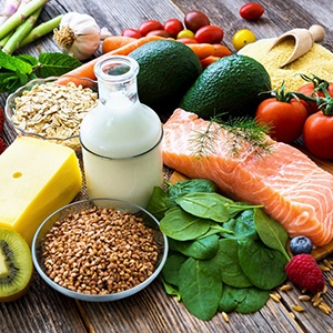 Healthy fruits, veggies, proteins, and dairy on a wooden table