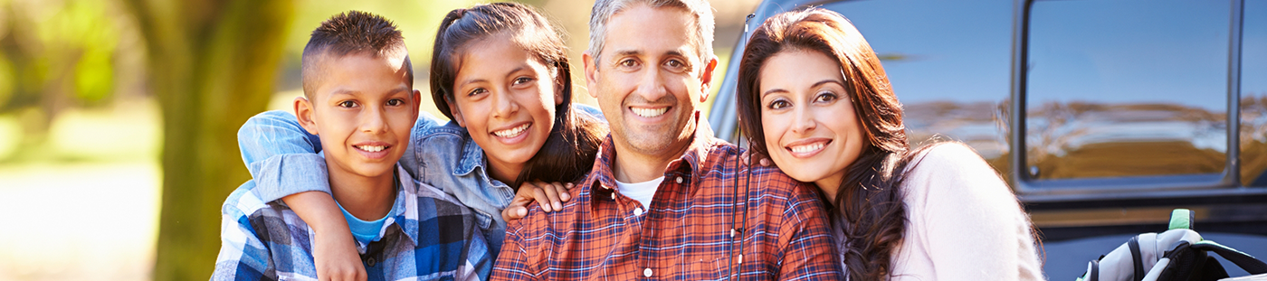 Family of four smiling outdoors after restorative dentistry in Arleta