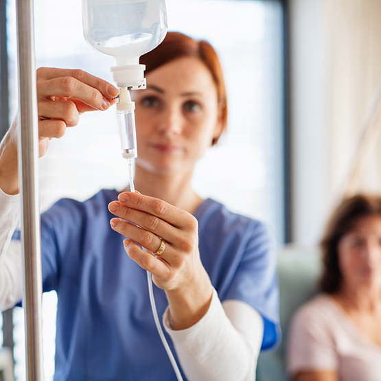 Nurse adjusting an I V drip