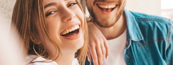 Man and woman laughing on couch together