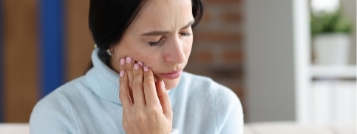 Woman holding the side of her face in pain