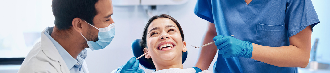 Woman in dental chair smiling right before receiving dental services in Arleta